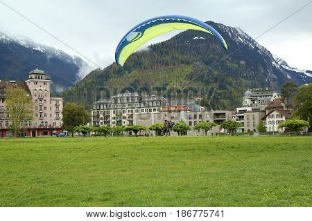 INTERLAKEN, SWITZERLAND - MAY 4, 2017: Tandem paragliding flights over the Swiss Alps in Interlaken, Switzerland
