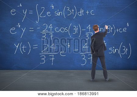 Rear view businessman writing with chalk against blue room