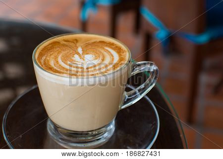 Coffee cup on black metal table in coffee shop