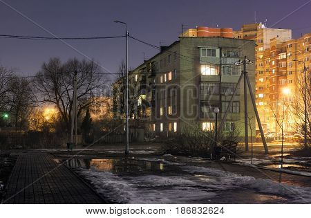 The old Soviet typical five story residential building next to the square without lighting. Night Scene