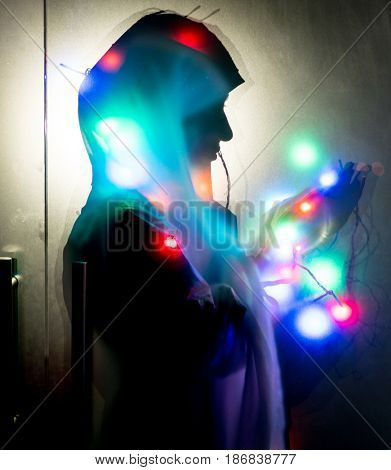 Muslim woman praying in dark room with nice lights around her