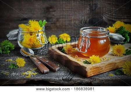 Dandelion jam in a jar and fresh flowers
