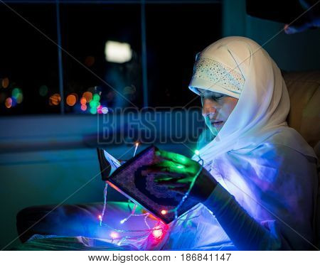Muslim woman praying in dark room with nice lights around her