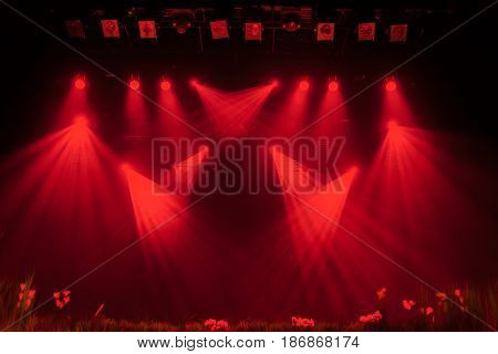 The red light from the spotlights through the smoke at the theater during the performance. Lighting equipment.