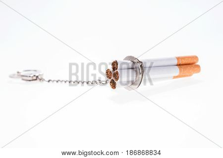 Addition concept with cigarettes and handcuffs on white background