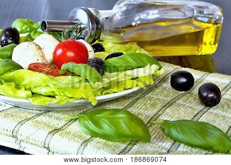 Caprese salad. Classic caprese salad. Italian traditional caprese salad ingredients. Mediterranean food. Caprese salad Tomato and mozzarella with basil leaves on wooden background.