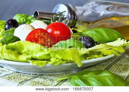 Caprese salad. Classic caprese salad. Italian traditional caprese salad ingredients. Mediterranean food. Caprese salad Tomato and mozzarella with basil leaves on wooden background.