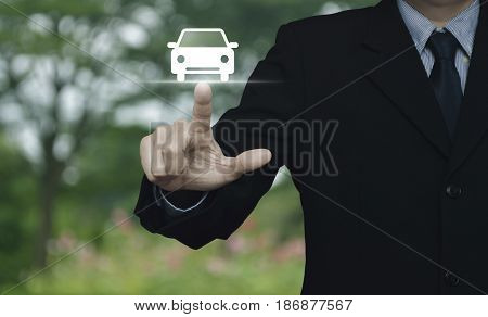 Businessman pressing car flat icon over blur flower and tree in park Business transportation service concept