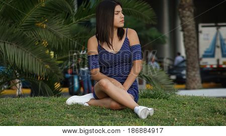 Unhappy And Serious Teen  Sitting on Grass