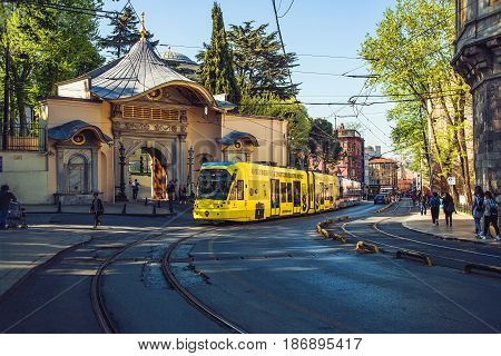 ISTANBUL TURKEY - MAY 2 2017: Yellow modern tram on the historical street moving from the Gulhane station against Fatih Bab Ali Osman gate background