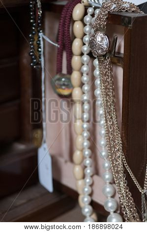 Necklaces hanging from the door of a jewlery box in an antique store