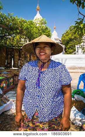 MANDALAY,MYANMAR - MARC 7, 2017: Unidentified Myanmar woman with thanaka on her smile face is happiness in Mandalay on March 7, 2017. Thanaka is a yellowish-white cosmetic paste made from ground bark