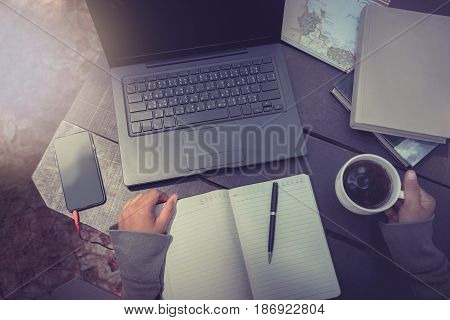Hands on a woman drinking coffee working in a natural garden on a vacation.