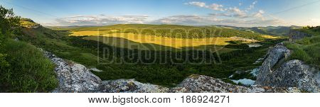 Evening panorama of the green valley. View from the top of the cave city Bakla in Crimea.