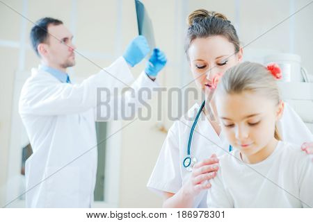 Little Caucasian Girl in the Emergency Room with Two Medical Doctors.