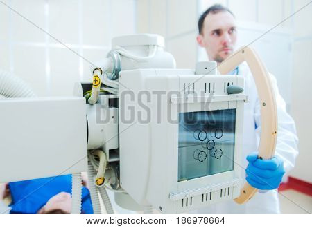 Hospital X Ray Scanner and the Scanning Caucasian Technician in His 30s.