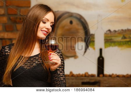 Woman Tasting Wine In Rural Cottage Interior