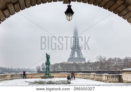 Paris, France - January 22, 2019: Snowfall Over France Reborn Statue On Pont De Bir-hakeim With Eiff