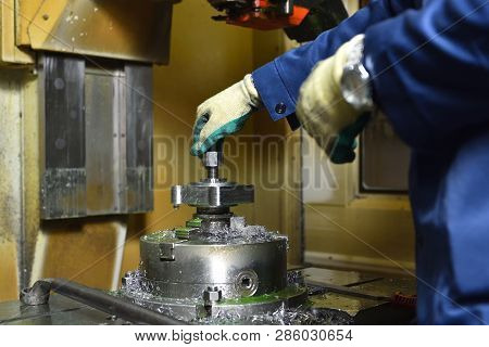 The Worker Installs A New Metal Part In The Chuck Spindles For Processing On The Cnc Machine. Hands 