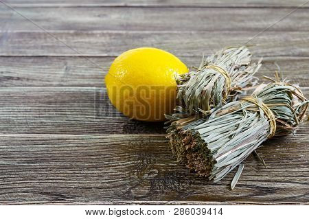Organic Dry Lemongrass (cymbopogon Flexuosus) In Bunches And Lemon Fruit On A Wooden Table. Herbs Fo