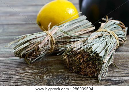 Organic Dry Lemongrass (cymbopogon Flexuosus) In Bunches And Lemon Fruit On A Wooden Table. Herbs Fo