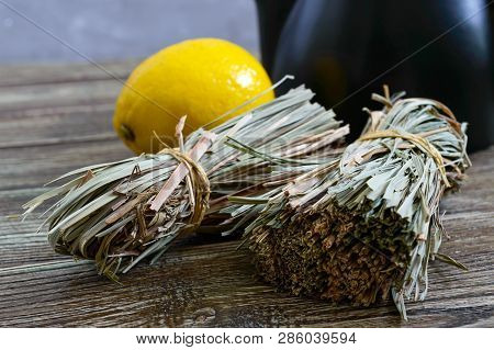 Organic Dry Lemongrass (cymbopogon Flexuosus) In Bunches And Lemon Fruit On A Wooden Table. Herbs Fo