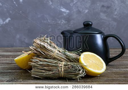 Organic Dry Lemongrass (cymbopogon Flexuosus) In Bunches And Lemon Fruit On A Wooden Table. Herbs Fo