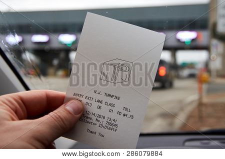 New York, Usa - December 14, 2018: A Hand Holding Ezpass Receipt. E Zpass Is Electronic Toll Collect