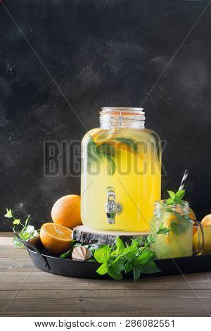 Lemonade With Orange, Lemon And Mint In Mason Jar On Black And Wooden Board. Summer Healthy Detox Dr