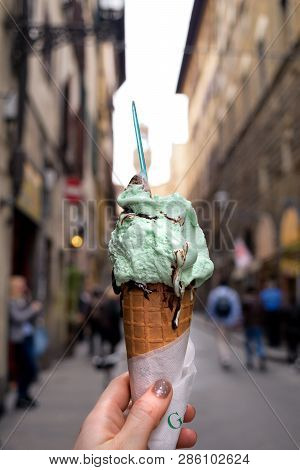 Traditional Italian Gelato, Ice Cream Waffle Cone In Female Hand Close Up With Italian Town Streen O