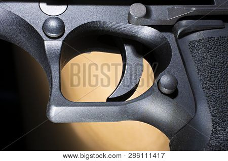 Semi Automatic Pistol Trigger With A Brown And Black Background