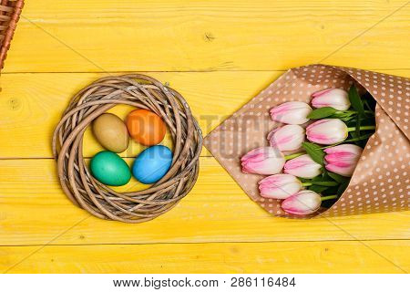 Spring Vibes. Colorful Bright Eggs And Bouquet Fresh Tulip Flowers On Yellow Background Top View. Sp