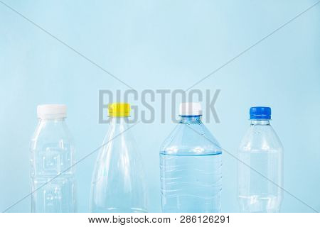 Plastic Waste Concept: Discarded Various Water Bottles In Blue Background, Detailed View. Single Use