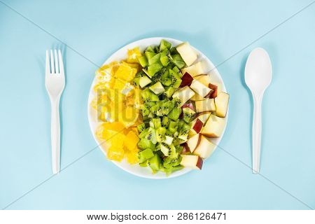 Plant Based Food Diet Concept. Top View Of Fresh Fruit On A Plate In Pale Blue Background