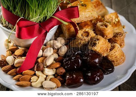 Nowruz Holiday Concept - Grass, Baklava Sweets, Nuts And Seeds, Copy Space