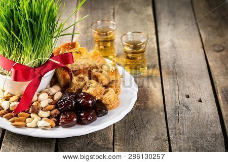 Nowruz Holiday Concept - Grass, Baklava Sweets, Nuts And Seeds, Copy Space