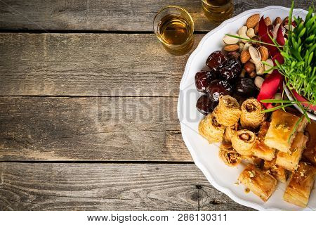 Nowruz Holiday Concept - Grass, Baklava Sweets, Nuts And Seeds, Copy Space