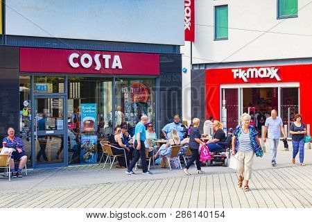 11 June 2018: St Austell, Cornwall, Uk - Costa Coffee Shop, With A Group Of People Sitting Outside.