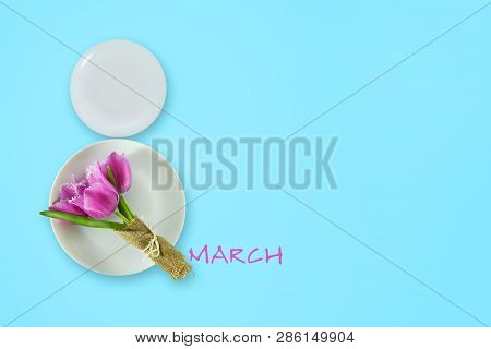 March 8 Made Up Of Plates With Tulips On A Blue Background. Copy Space. Happy Women's Day Background
