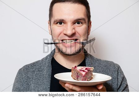 Closeup Portrait Young Cute Caucasian Man Smile, Hold Fork In His Teeth And White Round Plate With P