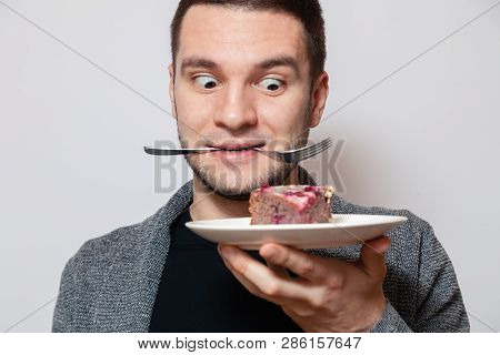 Closeup Portrait Young Cute Caucasian Man Smile, Hold Fork In His Teeth And White Round Plate With P
