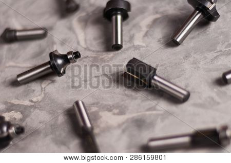 Scattered Set Of Steel Router Bit For Milling Cutter On Old Broken Worn Gray Concrete Floor