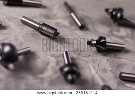 Scattered Set Of Steel Router Bit For Milling Cutter On Old Broken Worn Gray Concrete Floor