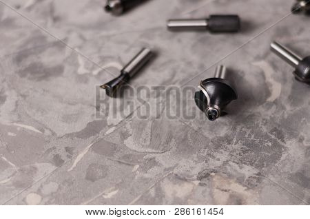 Scattered Set Of Steel Router Bit For Milling Cutter On Old Broken Worn Gray Concrete Floor With Cop