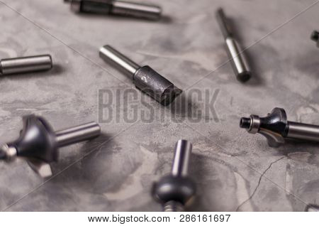 Scattered Set Of Steel Router Bit For Milling Cutter On Old Broken Worn Gray Concrete Floor