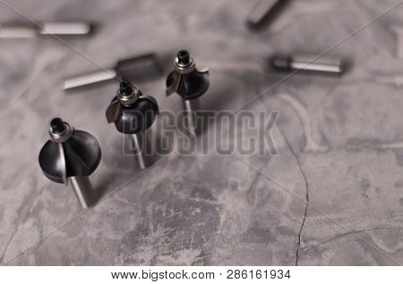 Scattered Set Of Steel Router Bit For Milling Cutter And Row Of Three Bits On Old Broken Worn Gray C