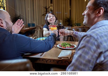 Group Of Friends Celebrate With A Toast And Raise Glasses In Celebration. Beautiful Young People Hav