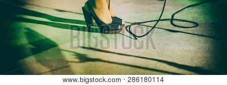 Female Legs In Shoes On Stage And Microphone Cord. Banner For Design.