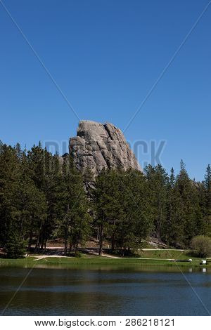 The Unique Rock Formation Of Little Devils Tower Rising Above The Tree Line And Sylvan Lake In Custe