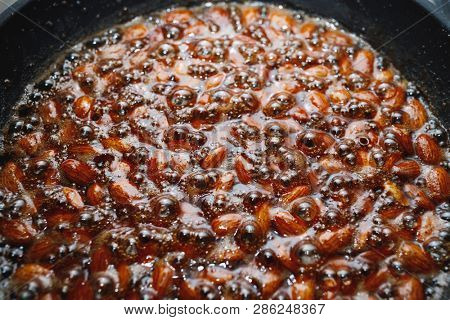roasted almonds with cinnamon sugar cooking process, close-up view